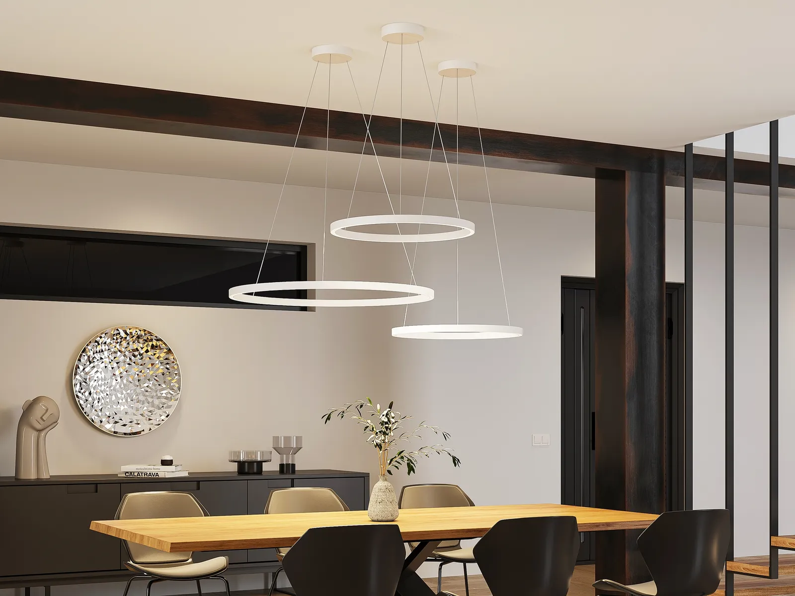 Molto Luce Perfora: drei weiße Ringleuchten in unterschiedlichen Höhen über einem Esstisch aus Holz