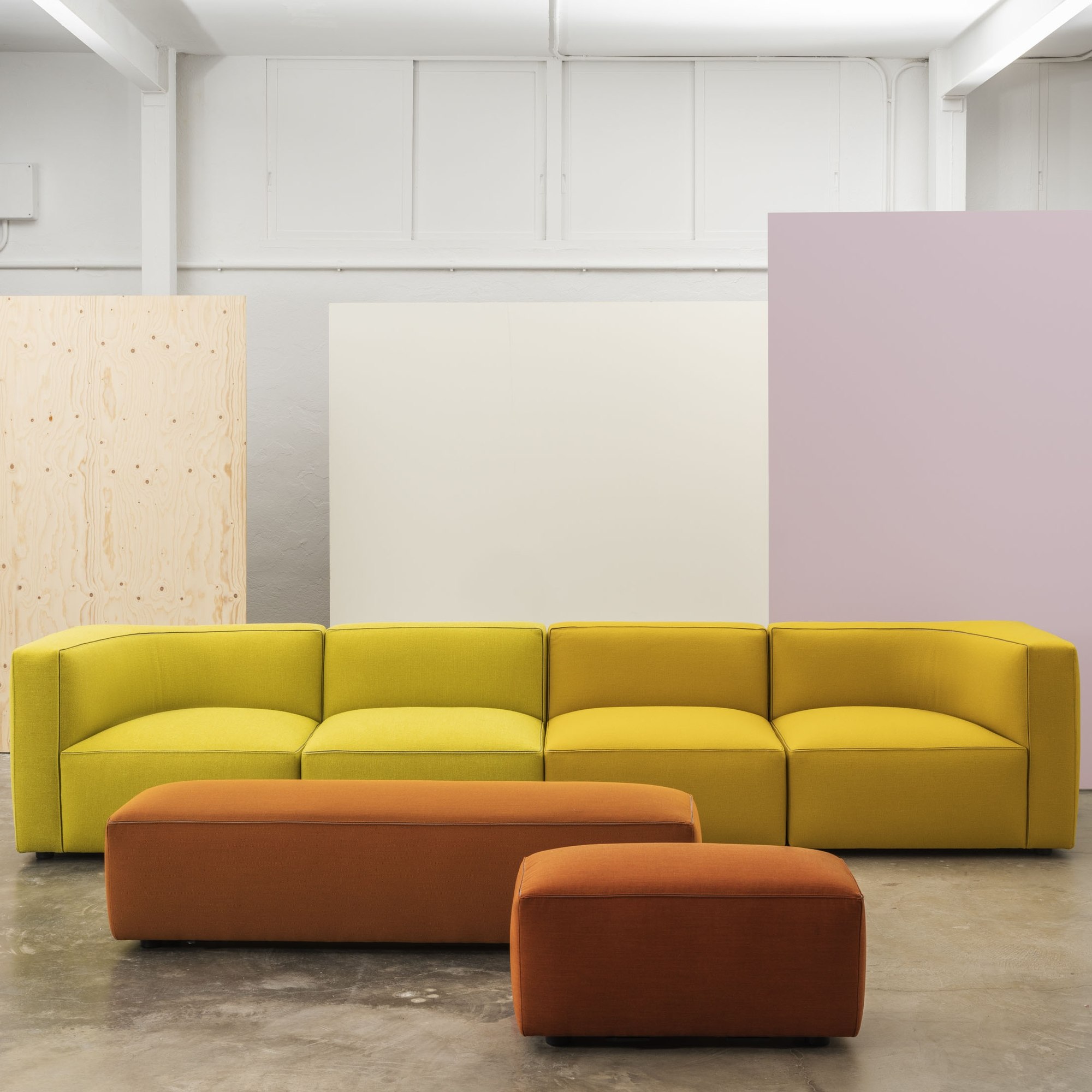 Gerades vierteiliges Dado-Sofa in Gelb mit zwei davor angeordneten Hockern in Rostorange