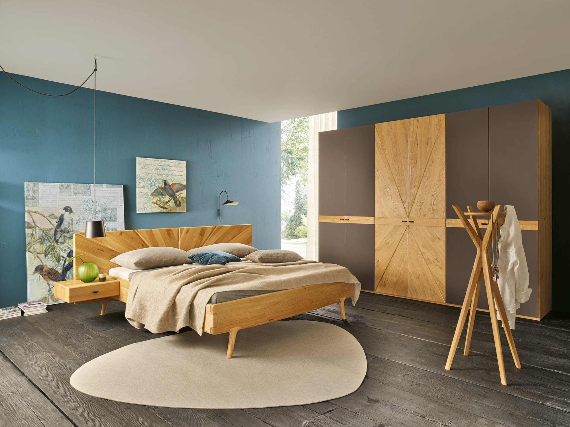 Sol-Schlafzimmer mit Holzbett und Kleiderschrank vor einer blauen Wand
