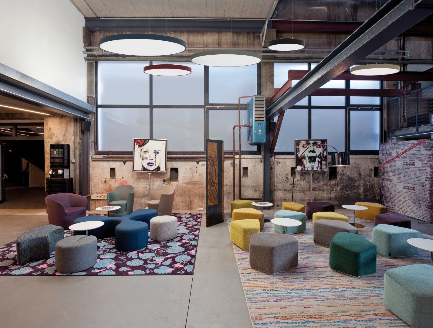 Molto Luce Bido: runde Pendelleuchten in mehreren Farben über einer Lounge mit Sesseln und Poufs