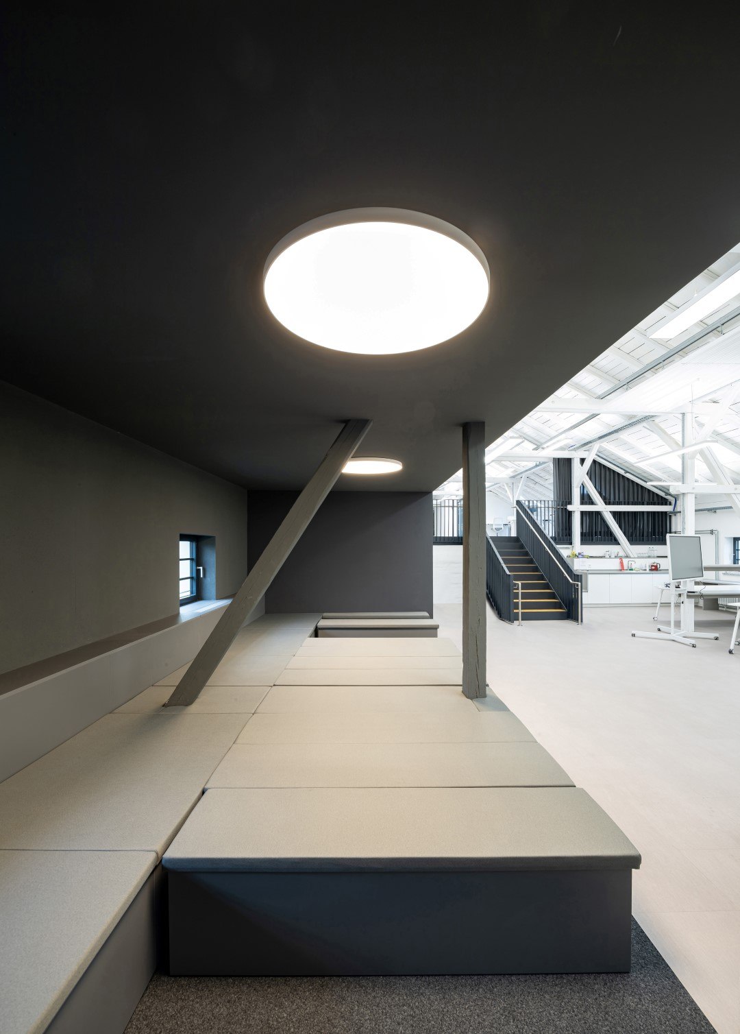Molto Luce Bido: runde Deckenleuchten über einer erhöhten Sitzbank in der Kühlhalle von Zukunft.Coburg.Digital
