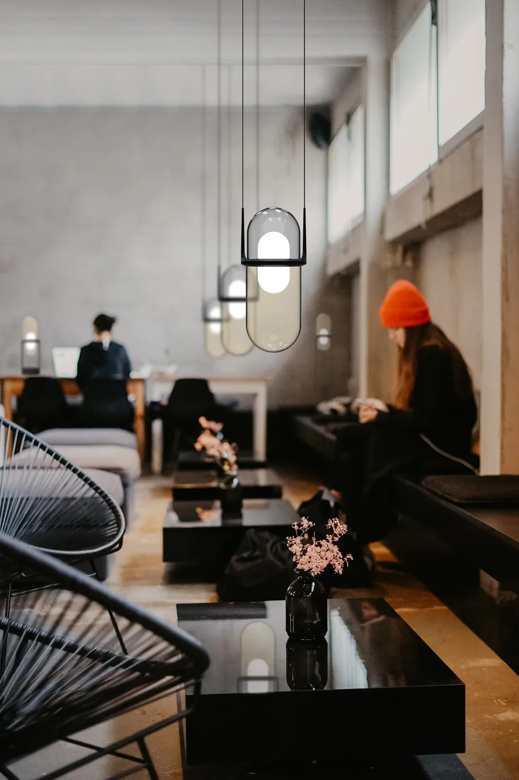 Molto Luce Pille: mehrere längliche Glas-Pendelleuchten über einem Lounge- und Sitzbereich