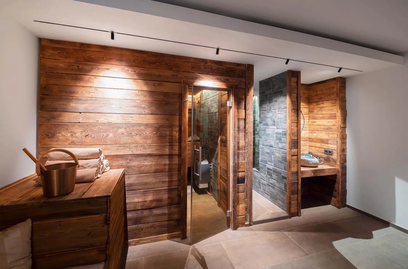 Molto Luce Magnetics: Deckenschiene mit Strahlern vor einer Sauna mit Holzwänden und angrenzender Dusche