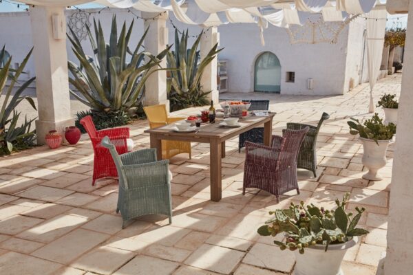 Unopiù Capri: farbige Geflechtsessel an einem Holztisch auf einer hellen Terrasse