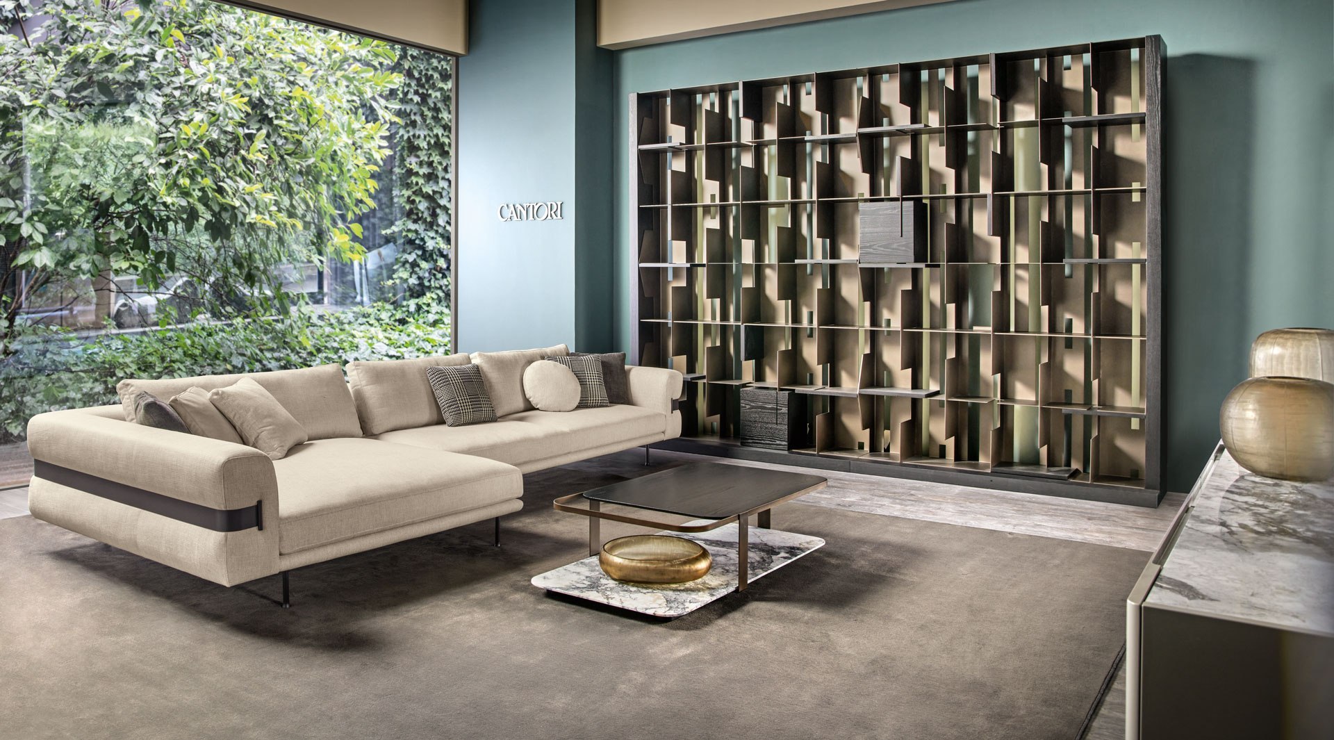 Valley Sofa mit Chaiselongue und Couchtisch vor einer großen Fensterfläche und einem offenen Regal